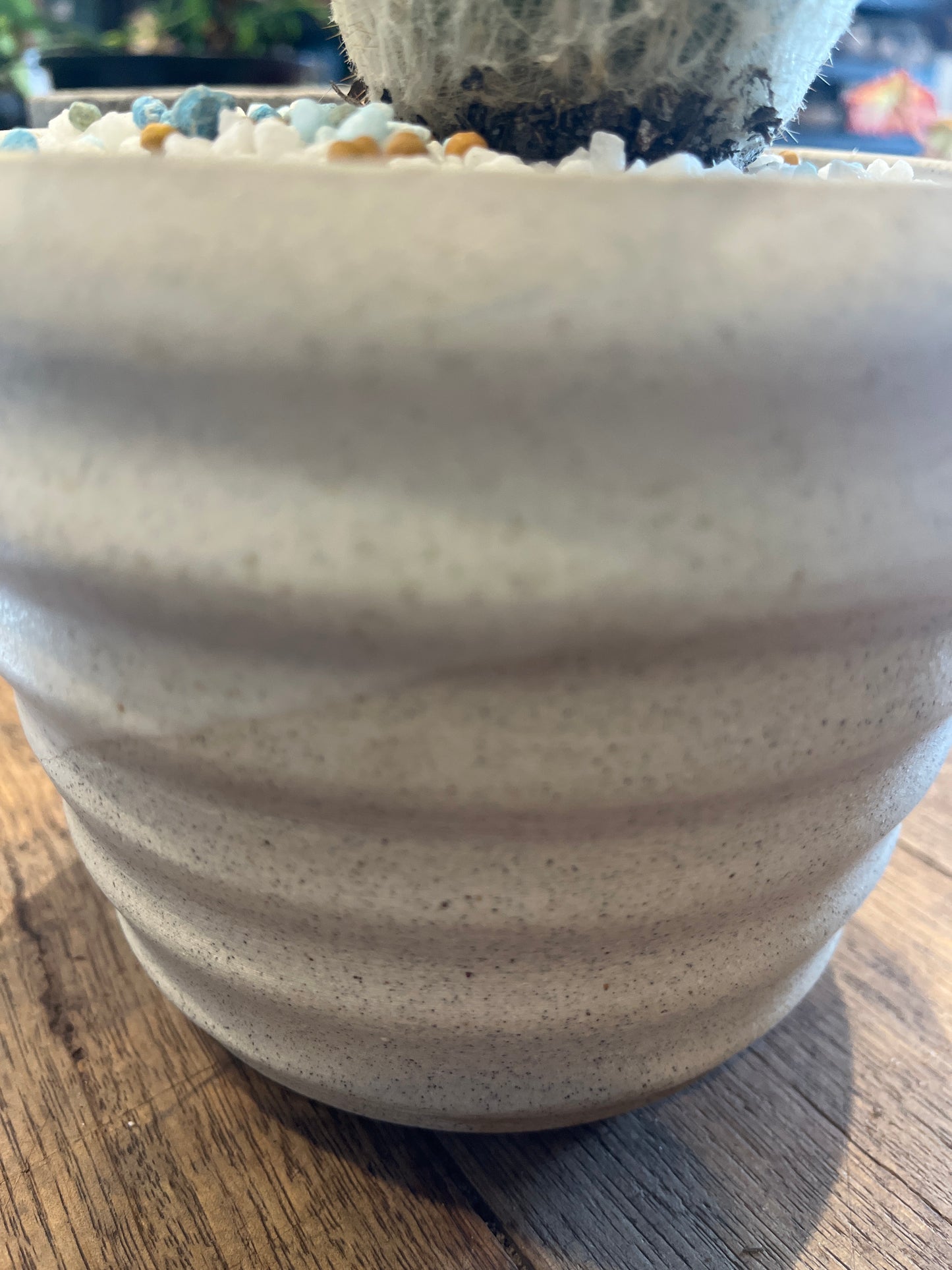 Close-up of a textured ceramic vase on a wooden surface