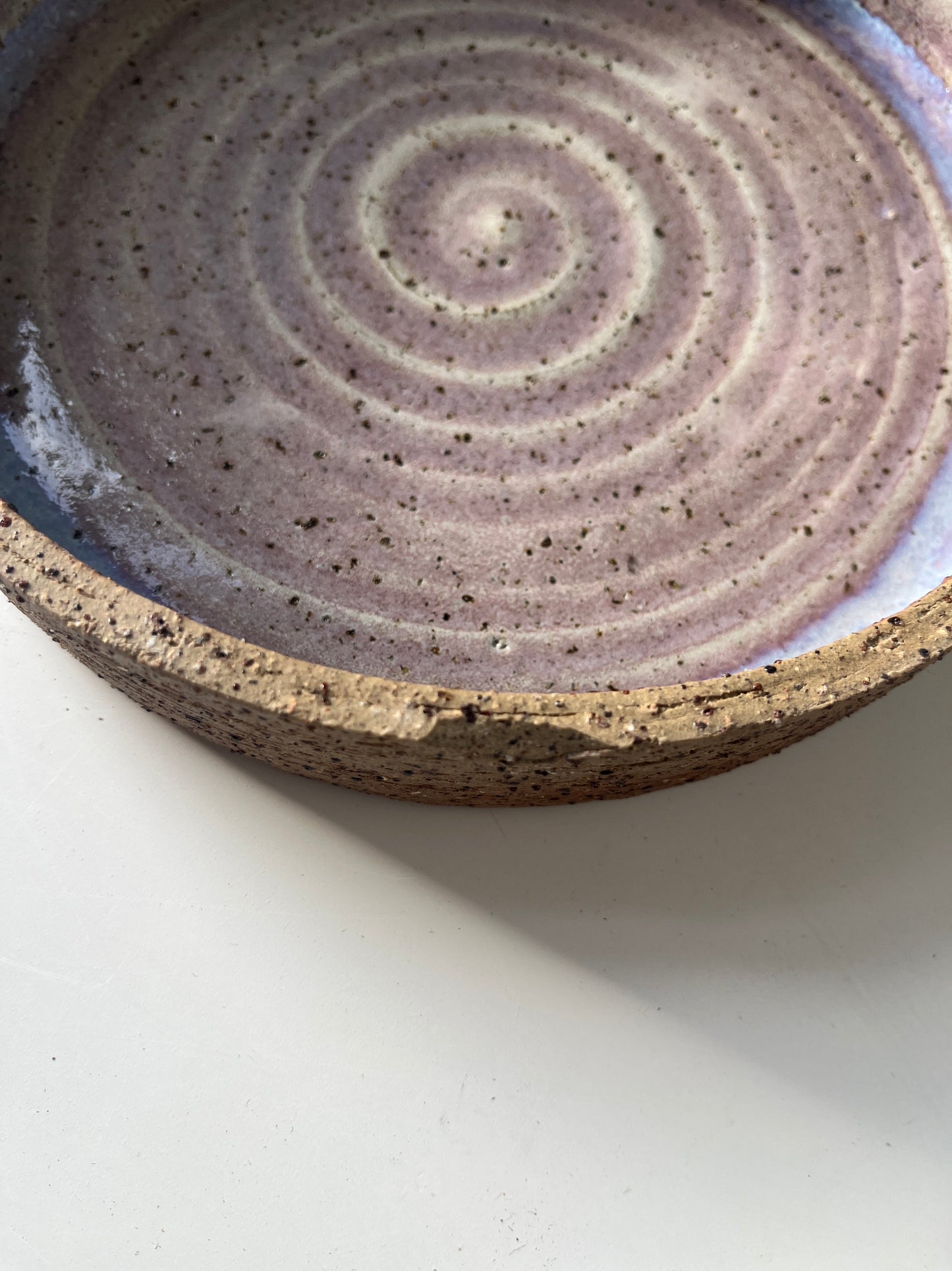 Close-up of a ceramic plate with concentric circle pattern on a white background