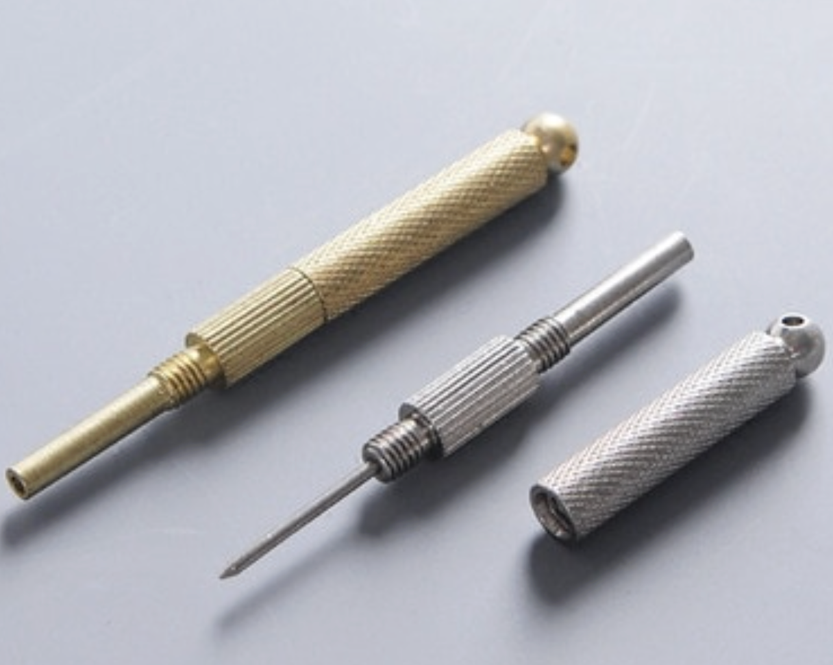 Three metal tools with textured handles on a light gray background