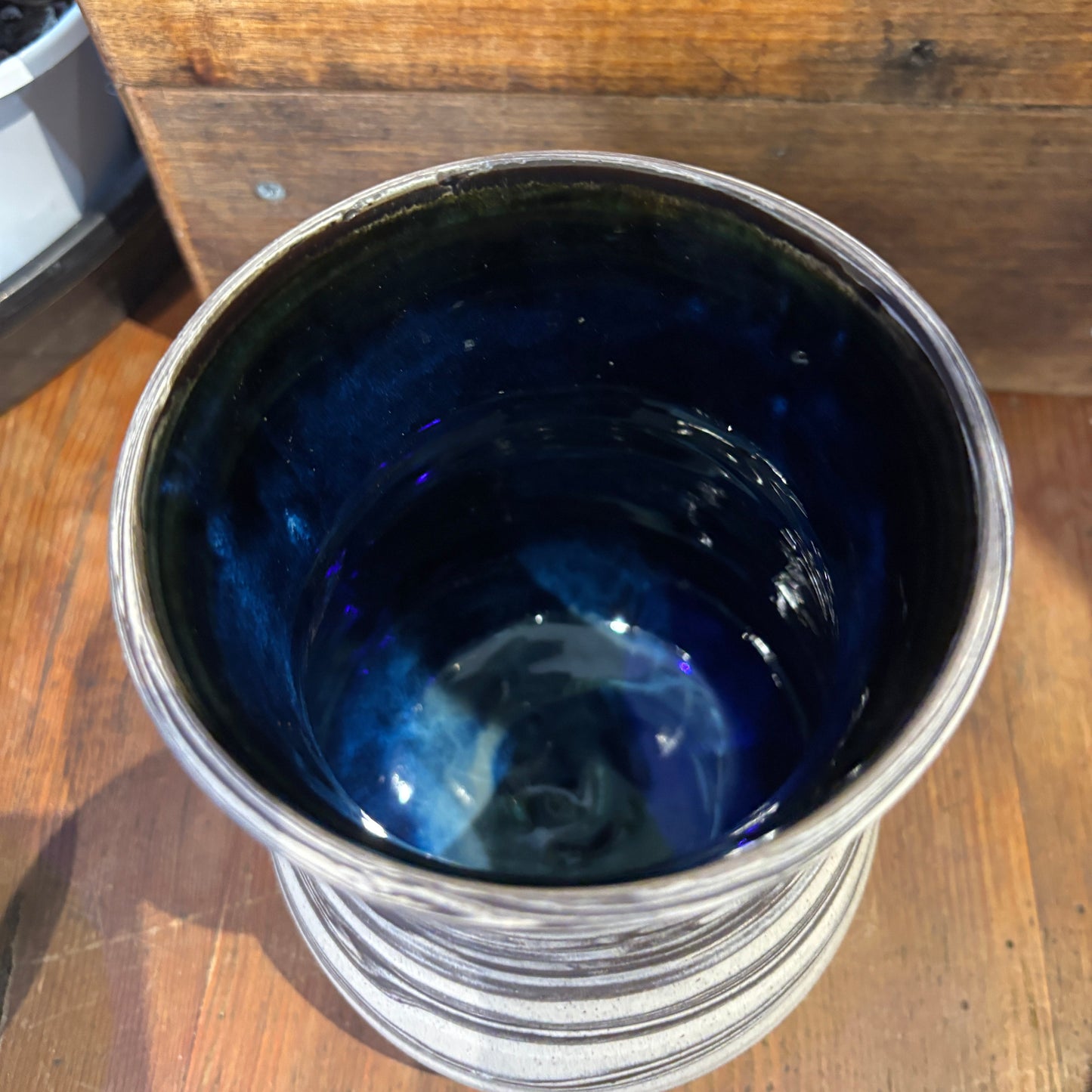 Blue glazed interior vase on a wooden surface