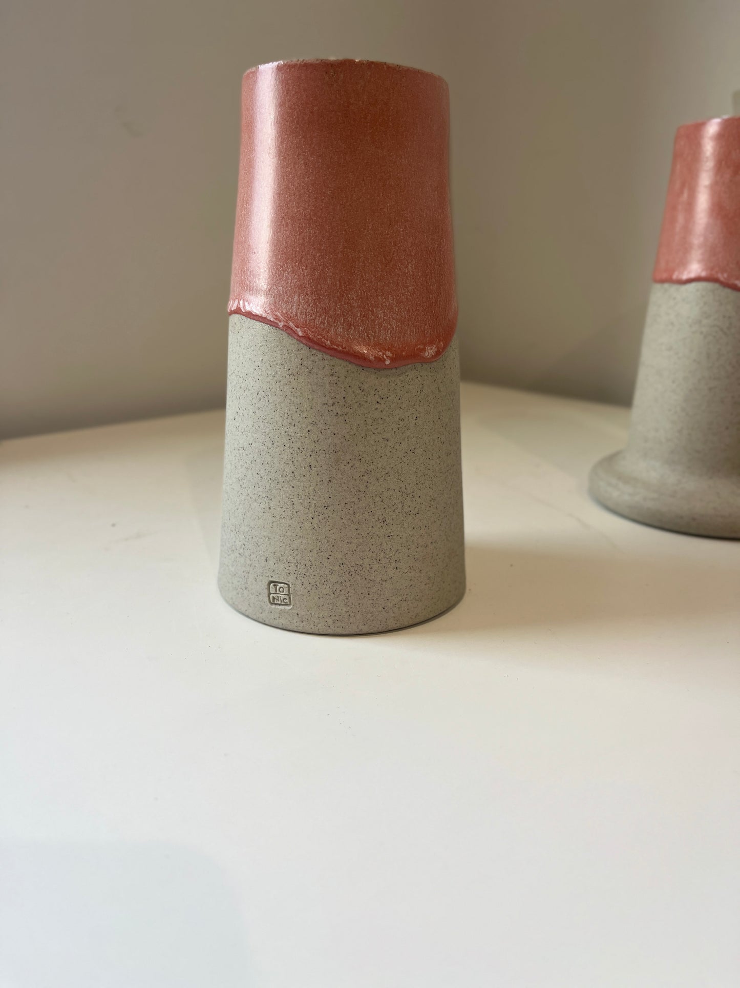 Cylindrical ceramic vase with two-tone design on a plain background