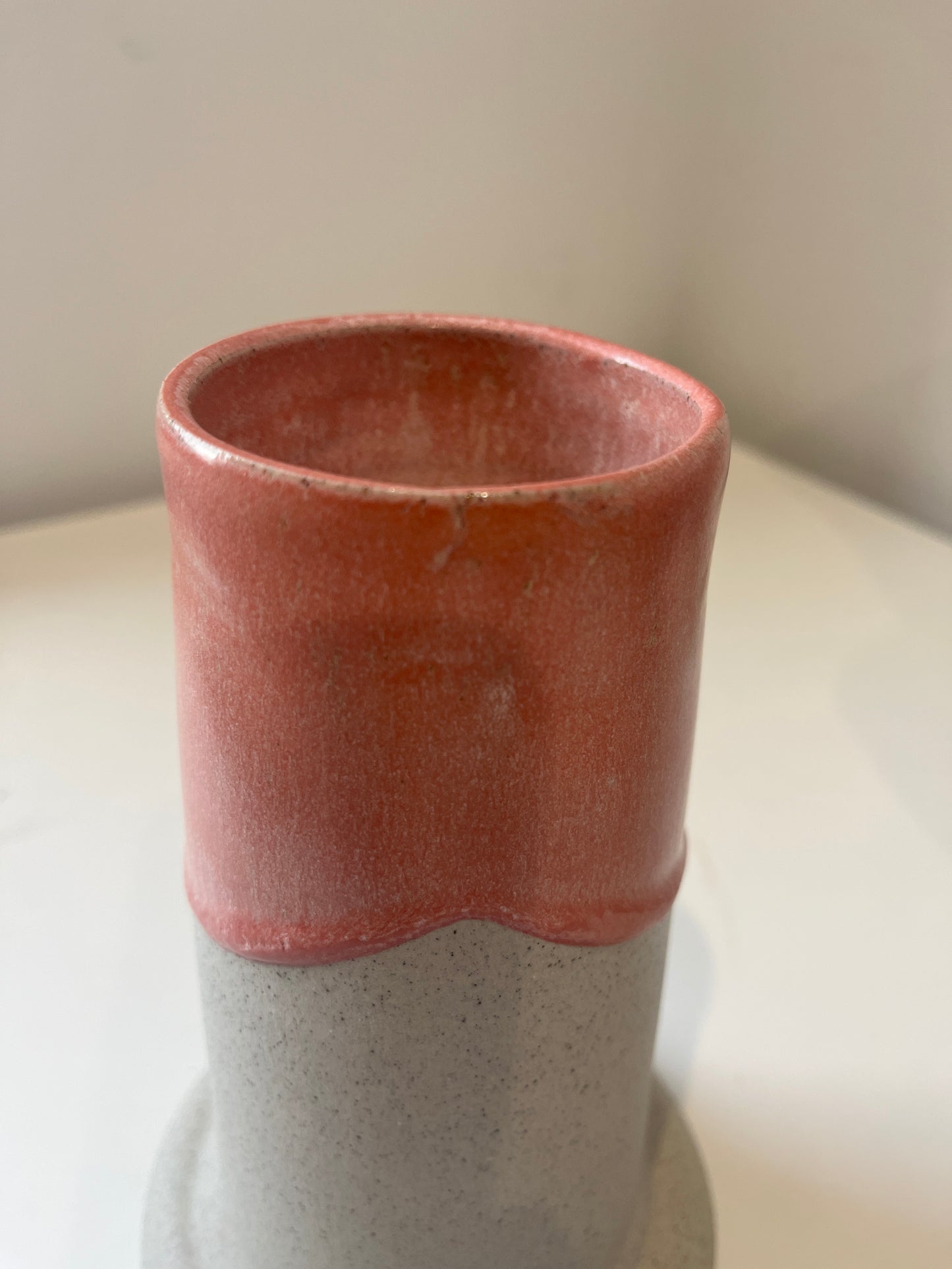 Close-up of a rose quartz cylindrical vase on a white background