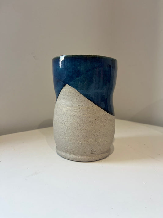 Ceramic vase with blue and gray design on a white surface