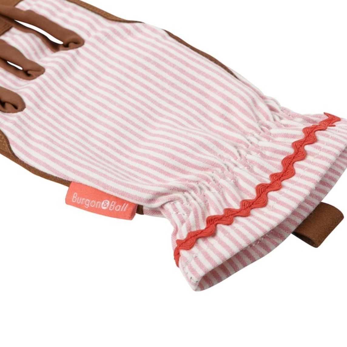 A single Burgon & Ball gardening glove with a pink and white striped fabric back, brown leather palms and fingers, and a red scalloped trim at the cuff.