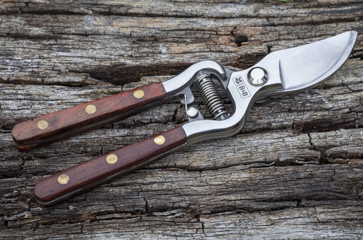 Pruning shears with wooden handles on a wooden surface
