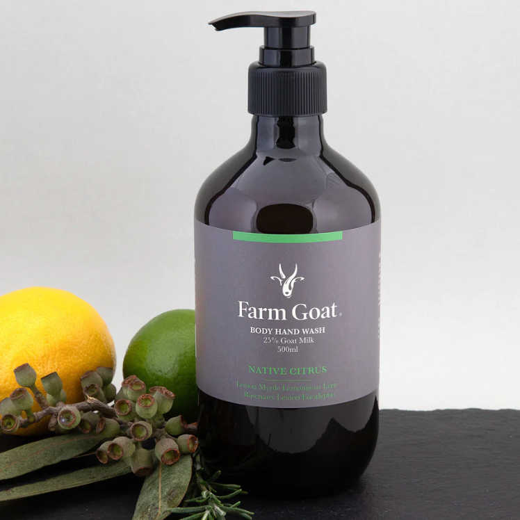 Farm Goat body wash bottle with lemons and green leaves on a gray background