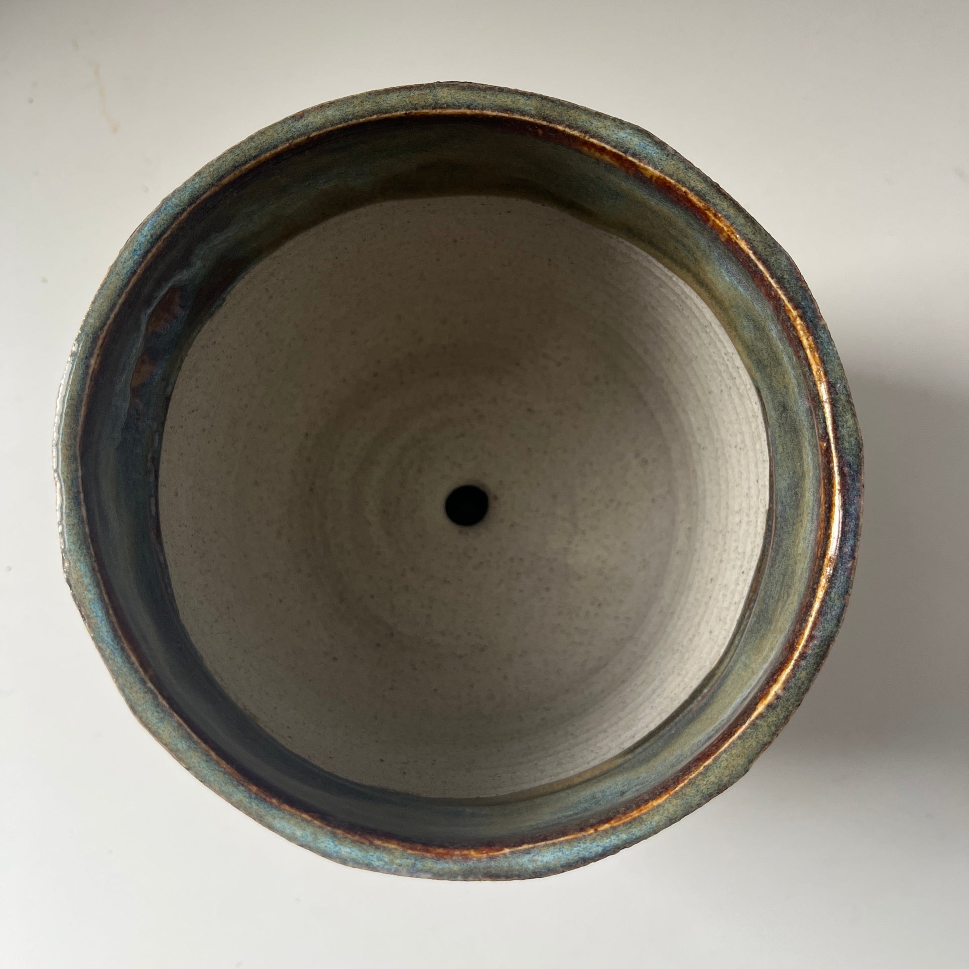Close-up of a ceramic planter with a dark rim on a light background
