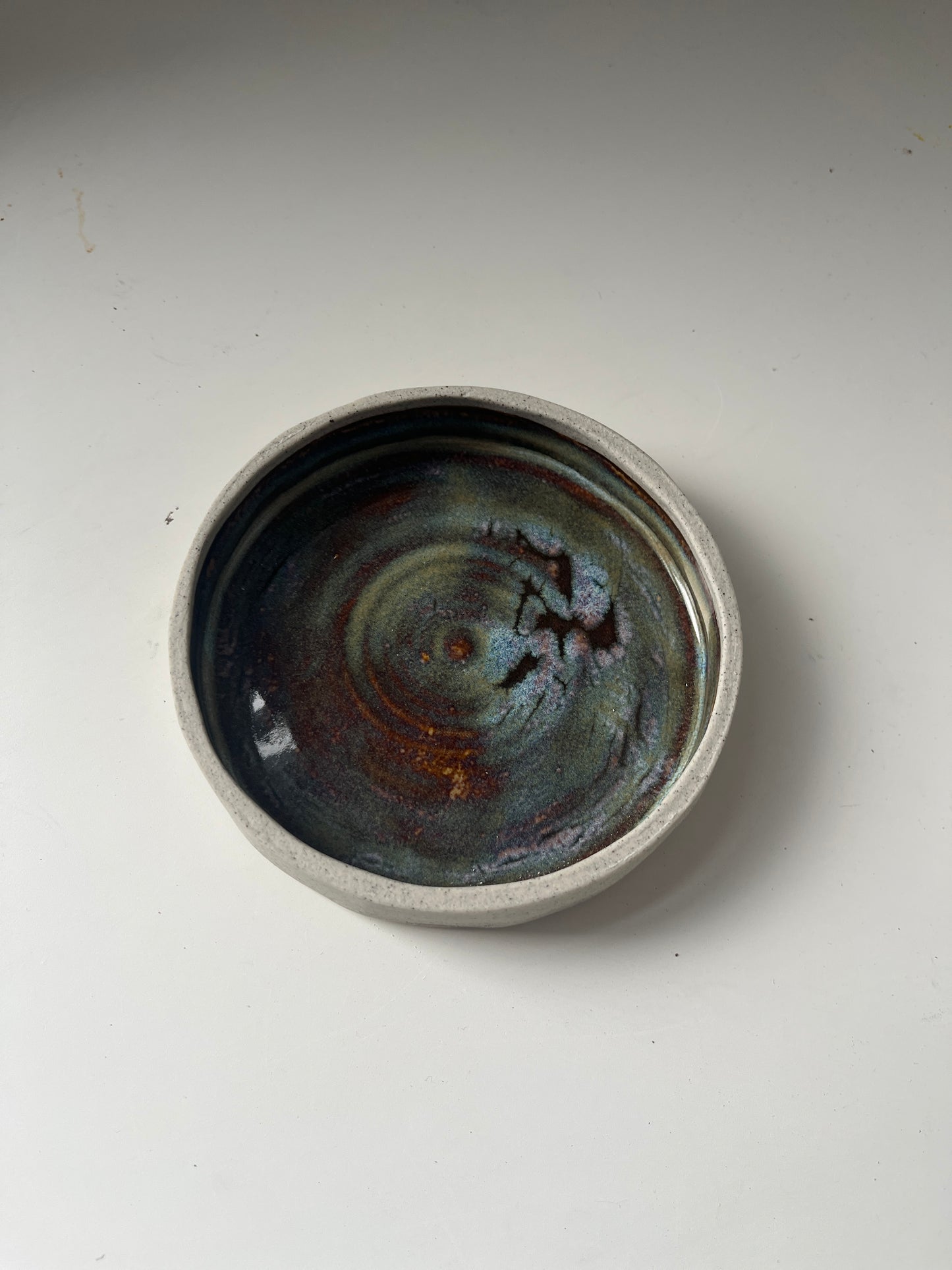 Ceramic saucer with a textured surface on a plain background