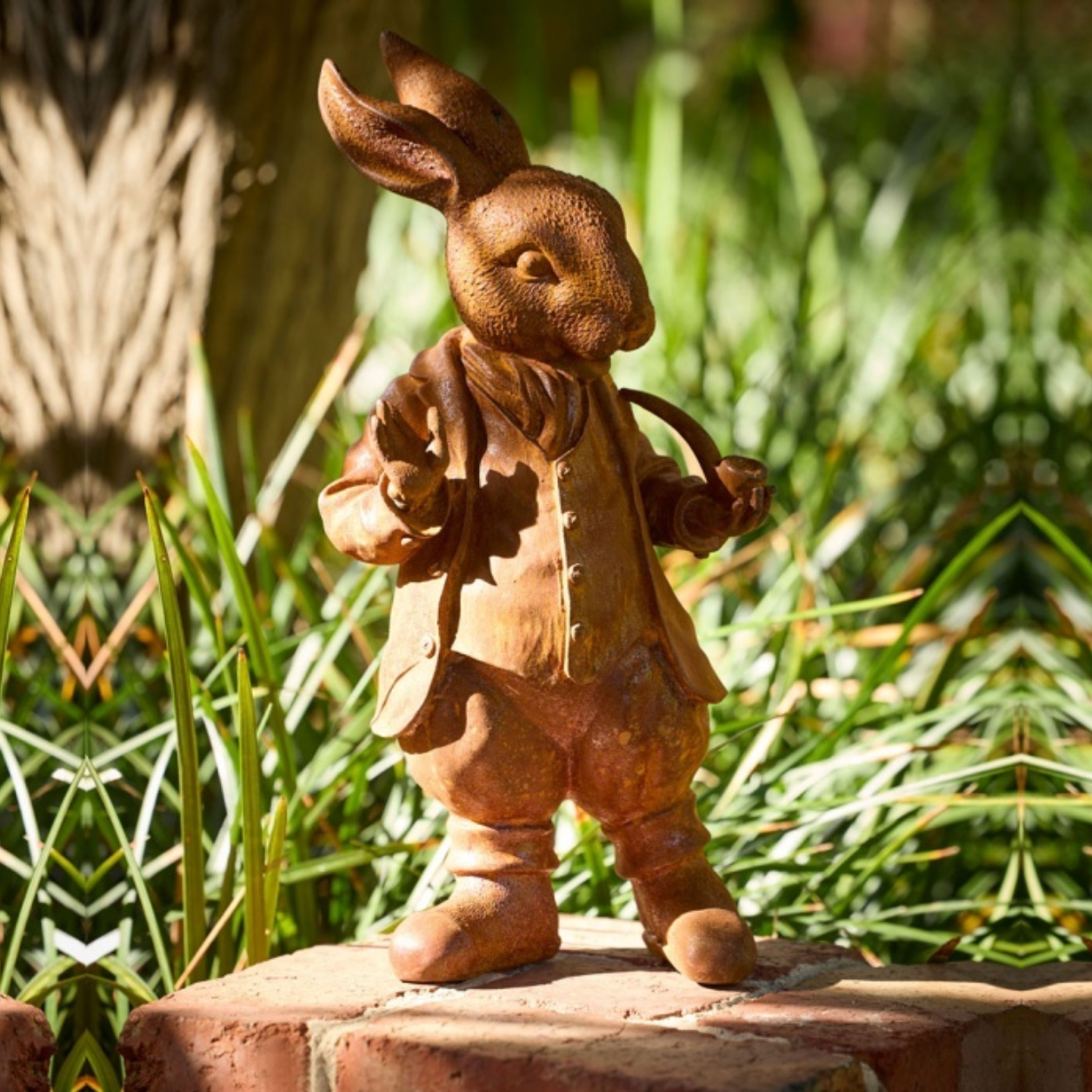 Cast Iron Mad Hatter rabbit figurine in a garden setting