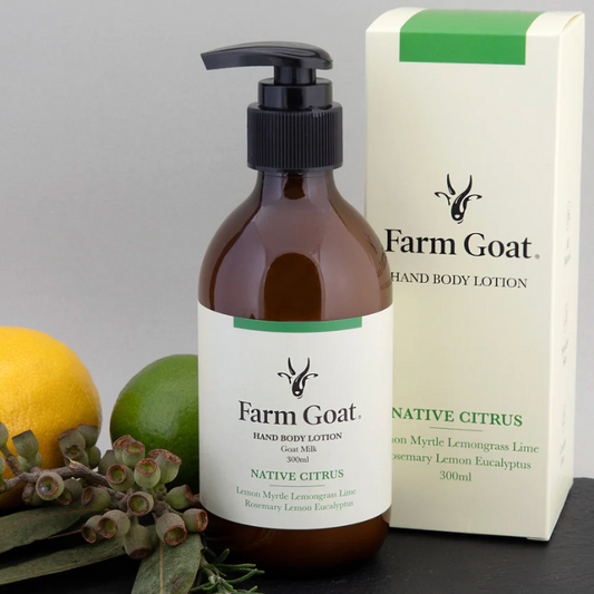 Farm Goat hand body lotion bottle and packaging with a lemon and lime on a gray background