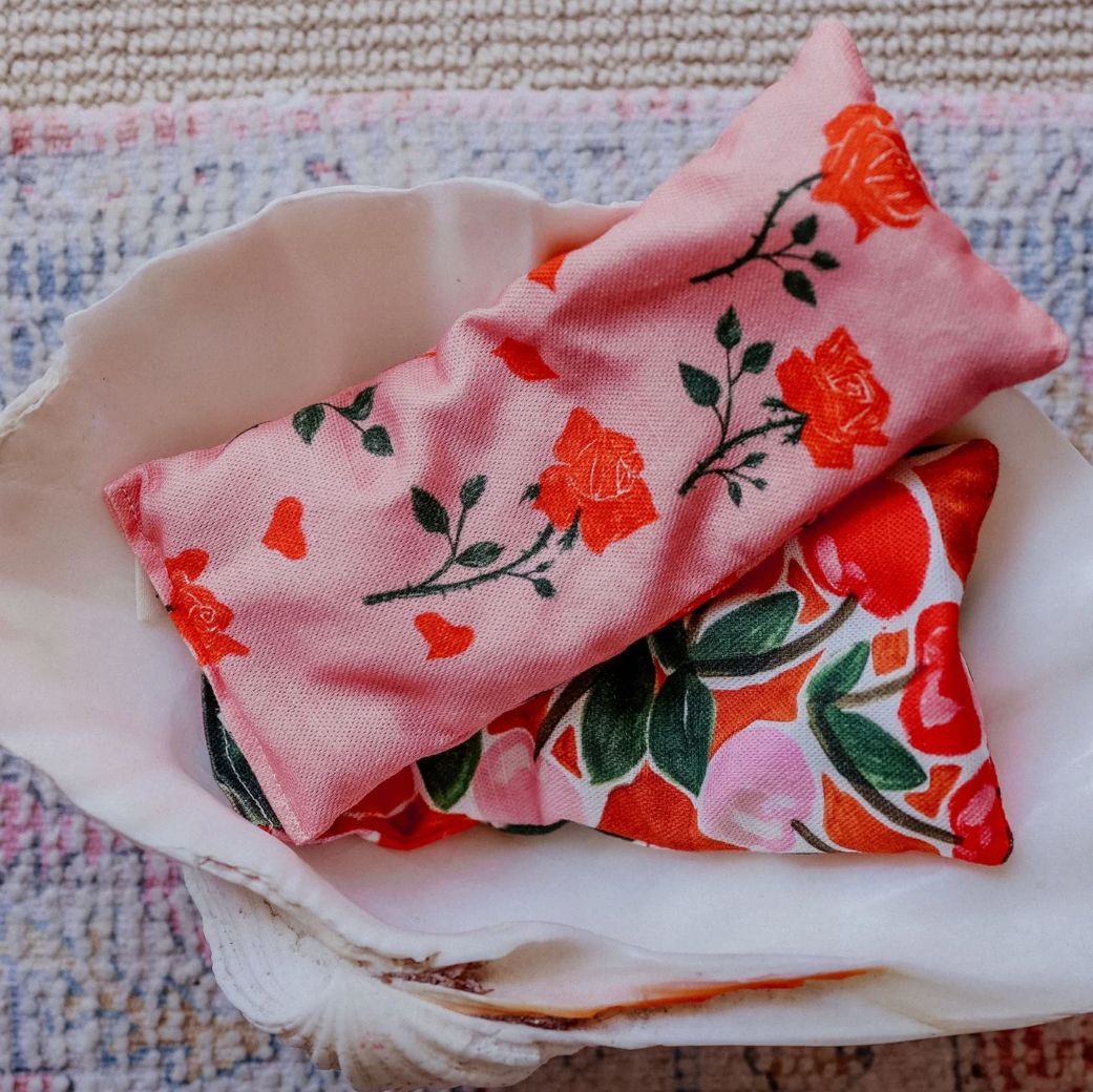 Pink and red floral fabric bags on a textured surface