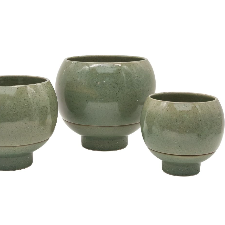 Three green ceramic pots of varying sizes on a white background