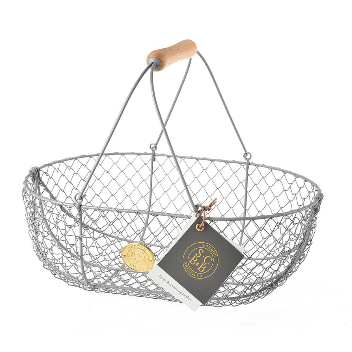 A gray wire mesh basket with a light wood handle, shown on a white background with a hanging brand tag and gold medallion.