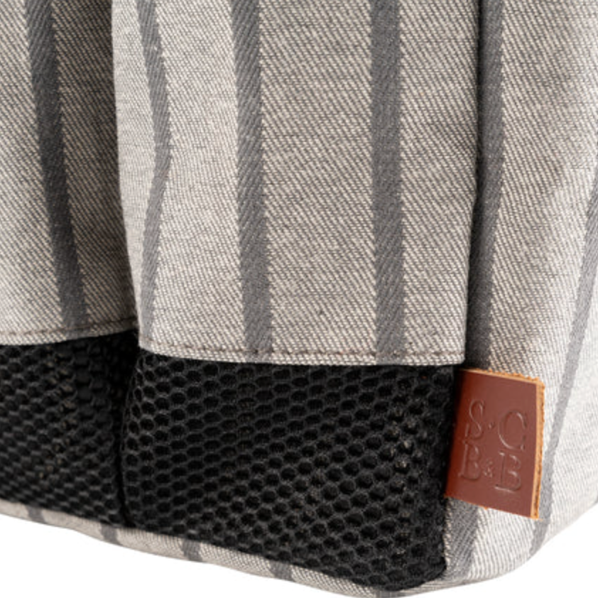 Close-up of a gray and black striped fabric with a brown tag on a white background