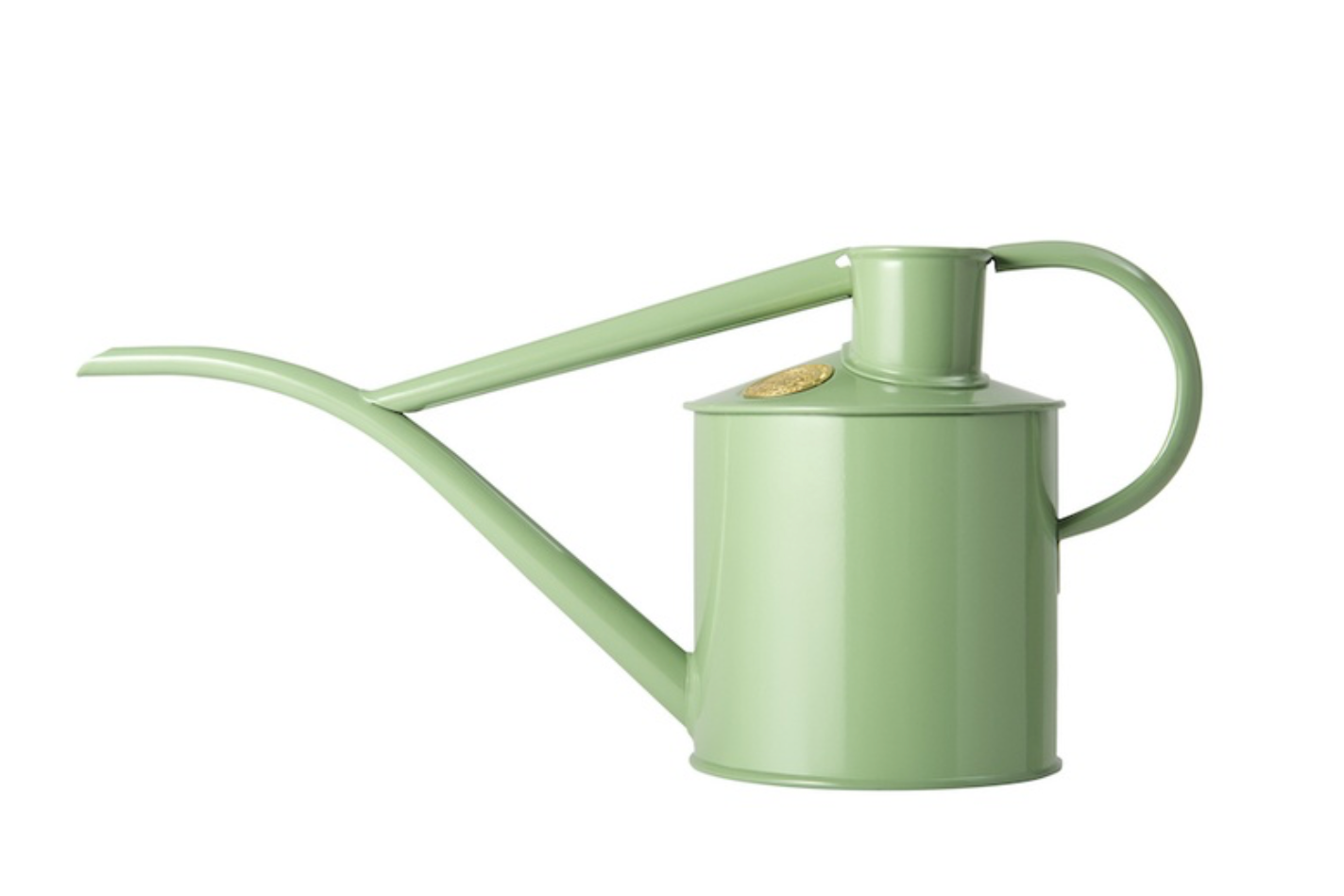 A light green metal watering can with a long narrow spout, a side handle, and a small round gold emblem on the lid, shown against a plain white background.