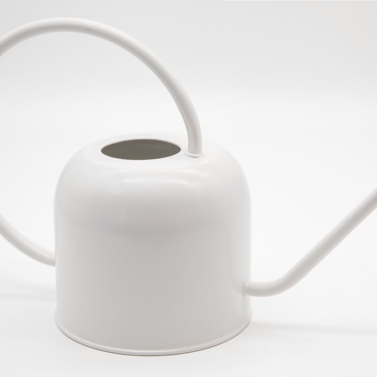 White watering can on a light gray background