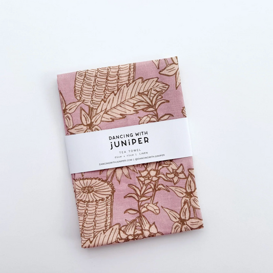 Pack of fabric tea towel with floral pattern and 'Dancing with Juniper' label on a white background