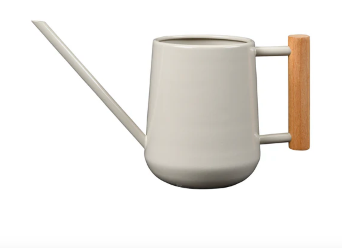 White watering can with a wooden handle on a white background